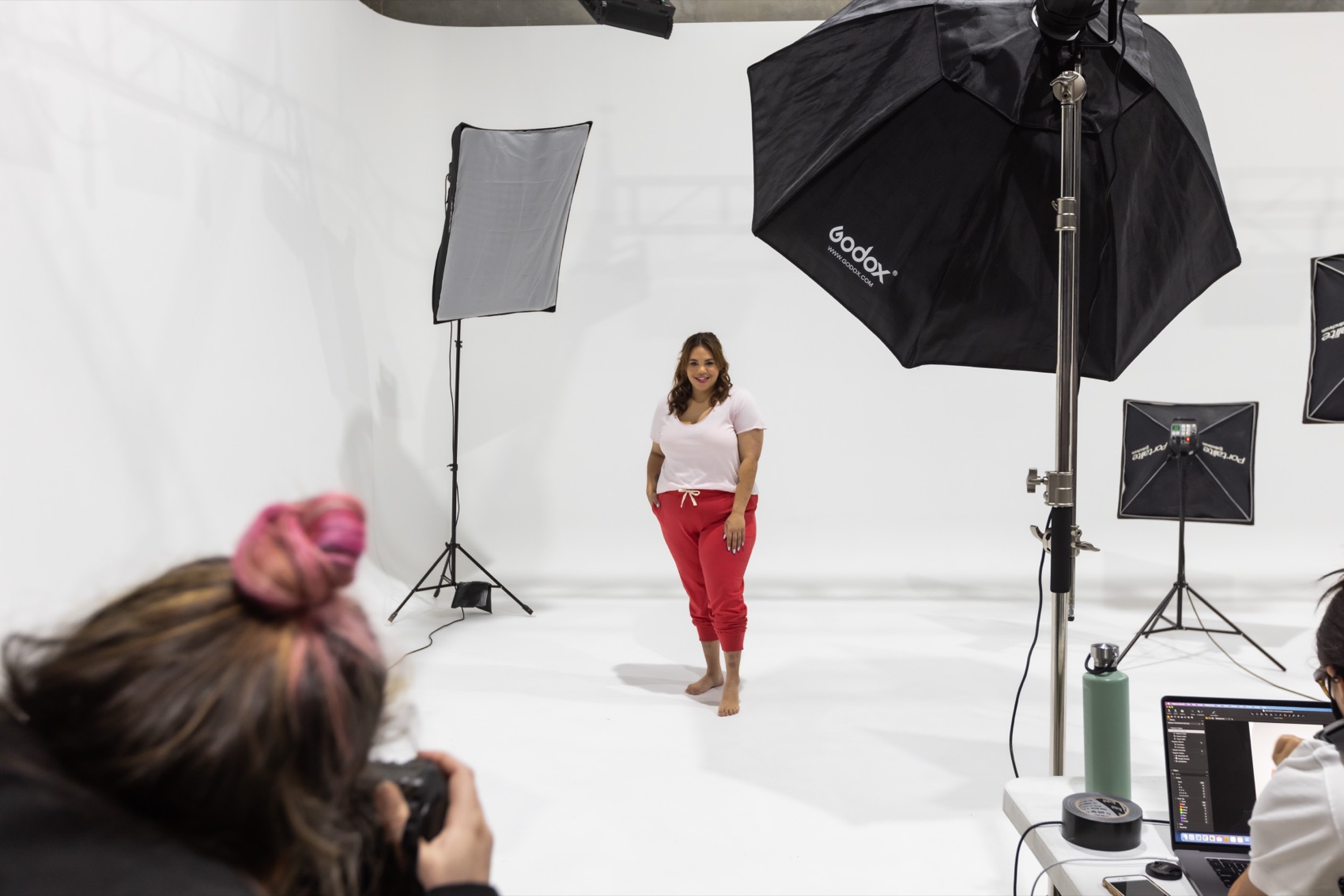 A model being photographed on the cyclorama